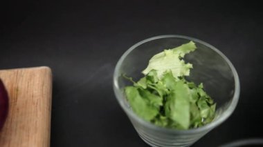 Siyah yüzeyde bir kase doğranmış avokado, tortilla cipsi ve yeniden kızartılmış fasulye.