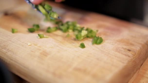 Handen langzaam hakken chili peper op snijplank — Stockvideo