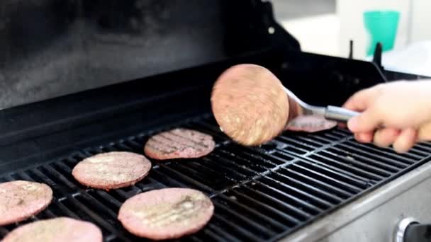 Αρσενικό χέρι flipping ωμό κρέας χάμπουργκερ στο μπάρμπεκιου σιδήρου — Αρχείο Βίντεο
