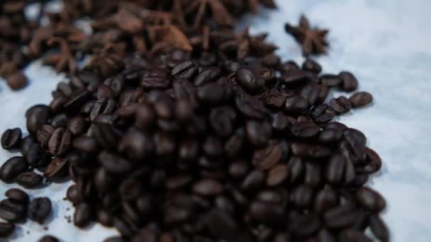 Colher de café cercado por pilhas de grãos de café na superfície branca — Vídeo de Stock