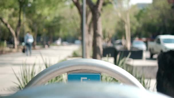 Sinal de estacionamento de bicicleta azul no arco de metal com árvores como fundo — Vídeo de Stock