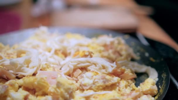 Míchaná vejce s nakrájenou krůtí šunkou na kulaté mřížce — Stock video