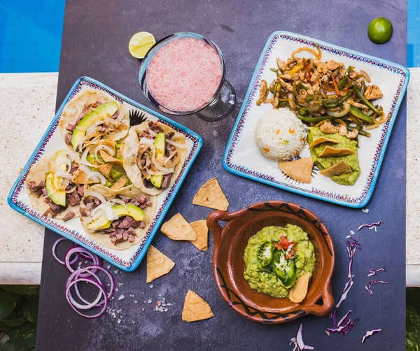 Deliciosos condimentos e pratos tradicionais mexicanos na superfície escura Imagem De Stock