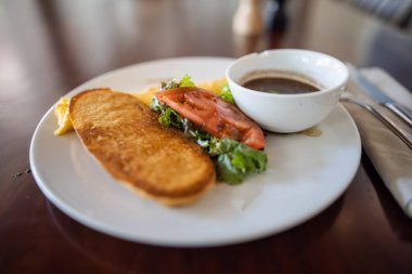 Lezzetli omlet, sebze, tost ve kahverengi masanın üstünde fasulye.