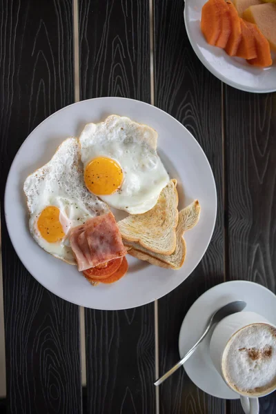 Läcker frukost med stekta ägg och en kopp kaffe på svart bord — Stockfoto