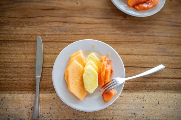 Delicious pineapple, melon, and papaya slices on wooden table — Stock Photo, Image