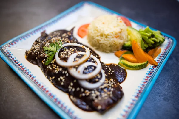 Tradiční mexické jídlo s krtkem, rýží a zeleninou nad tmavým povrchem Royalty Free Stock Fotografie