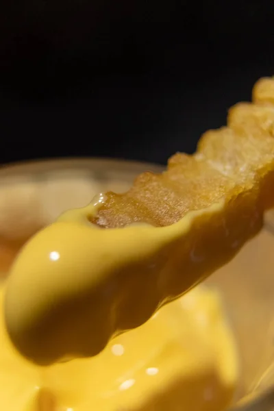 Vlnité hranolky namáčené do roztaveného sýra — Stock fotografie