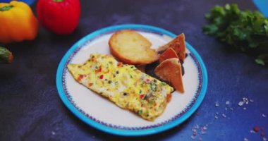 Lezzetli omlet, tost ve siyah yüzeyde yeniden kızartılmış fasulye tabağı.