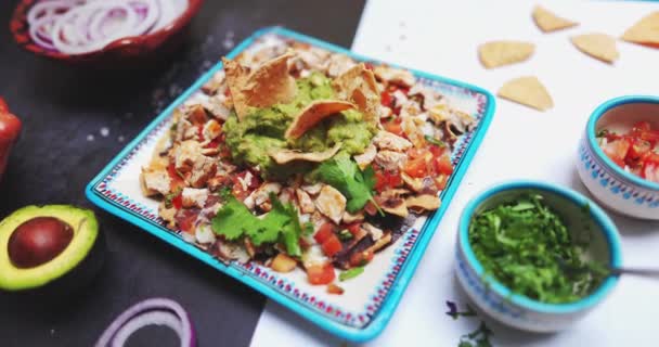 Plaat van heerlijk gehakt vlees met guacamole op tweekleurig oppervlak — Stockvideo