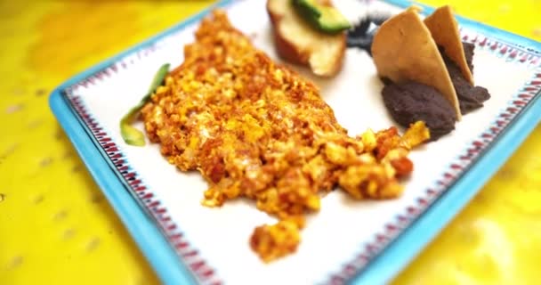 Placa de huevos revueltos picantes y chips de tortilla en la superficie amarilla — Vídeos de Stock