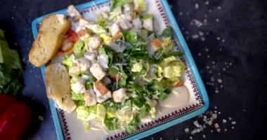 Sebzelerle ve siyah yüzeyde tuzla çevrili lezzetli salata tabağı.