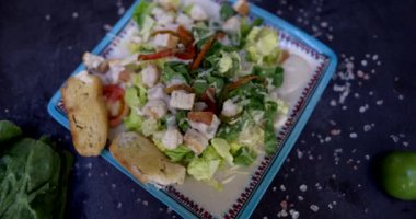 Sebzelerle ve siyah yüzeyde tuzla çevrili lezzetli salata tabağı.