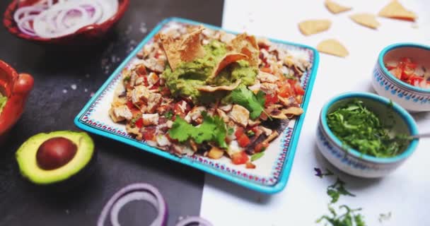 Teller mit köstlichem gehacktem Fleisch mit Guacamole auf zweifarbiger Oberfläche — Stockvideo