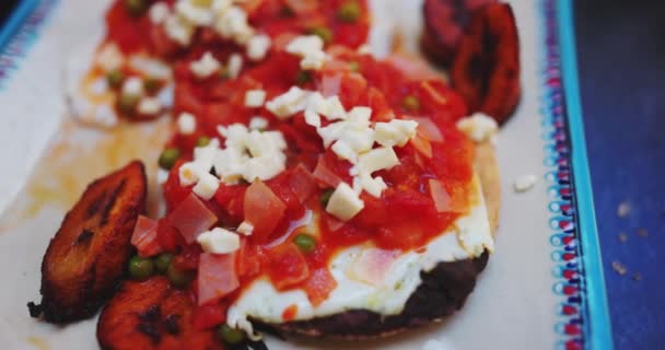 Placa de huevos rancheros y rodajas de plátano frito sobre superficie oscura — Vídeos de Stock