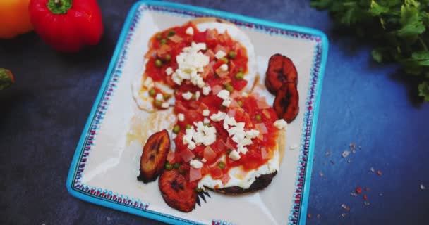 Teller mit Huevos Rancheros und gebratenen Bananenscheiben auf dunkler Oberfläche — Stockvideo