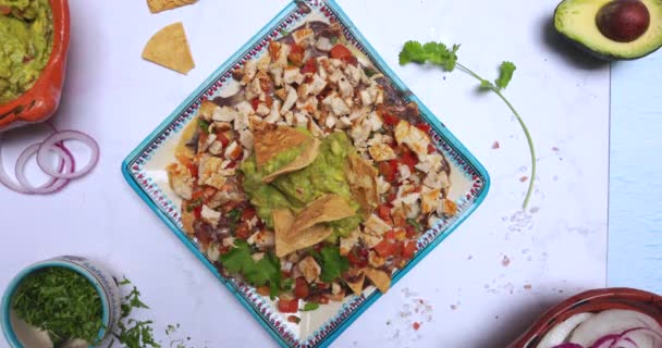 Pyszne posiekane mięso z guacamole na białej powierzchni otoczone przyprawami — Wideo stockowe