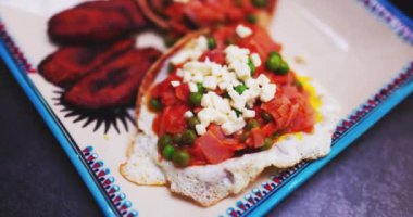 Huevos rancheros ve kızarmış muz dilimleri.