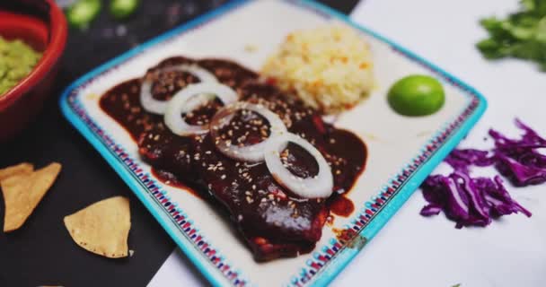 Deliciosa toupeira, arroz, fatias de cebola e mais comida na superfície de duas cores — Vídeo de Stock