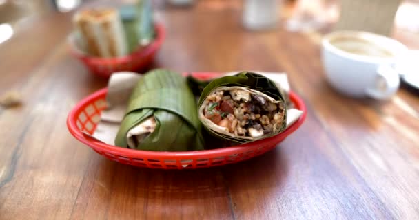 Lekkere burrito 's gewikkeld met bananenblad op houten tafel — Stockvideo