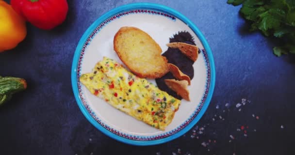 Prato com deliciosa omelete, torrada e feijão refrito na superfície preta — Vídeo de Stock