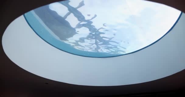 Yuvarlak pencereden mavi dalgalı suyun pürüzsüz görüntüsü — Stok video