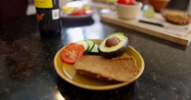 Erkek eller şarap şişesini ve camları sebzelerin yanına koyuyor.