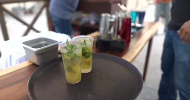Close-up van drie glazen limonade met muntblaadjes op zwart dienblad — Stockvideo