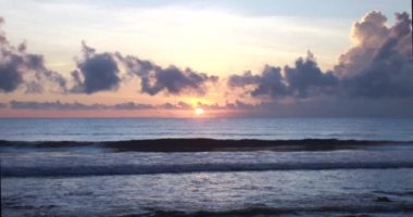 Harika bir gün batımı manzarası ve sahilin yakınındaki okyanus dalgaları.