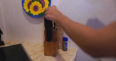 Eller bıçağı kaldırır ve güzel ayçiçeği resminin altında tahta keser.
