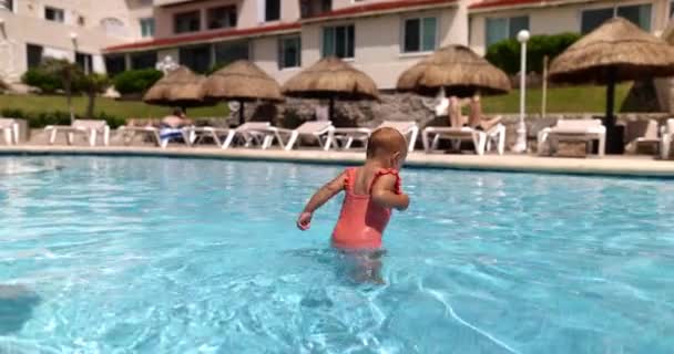 Leuke peuter wandelen in ondiep zwembad in slow motion — Stockvideo