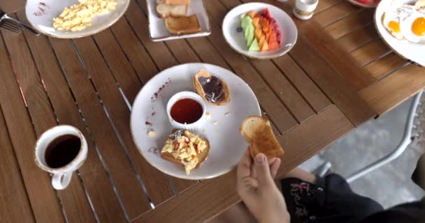 Vrouwelijke handen die langzaam gebakken ei op toast boven houten tafel leggen — Stockvideo