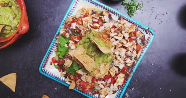 Lahodné nakrájené maso s guacamole na černém povrchu obklopeno koření — Stock video