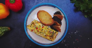 Lezzetli omlet, tost ve siyah yüzeyde yeniden kızartılmış fasulye tabağı.
