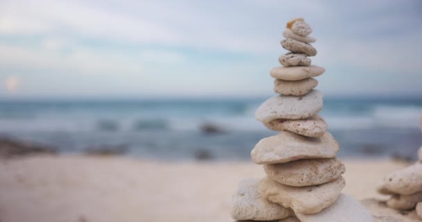 Rocas marinas apiladas una sobre la otra en la playa con el océano como fondo — Vídeos de Stock