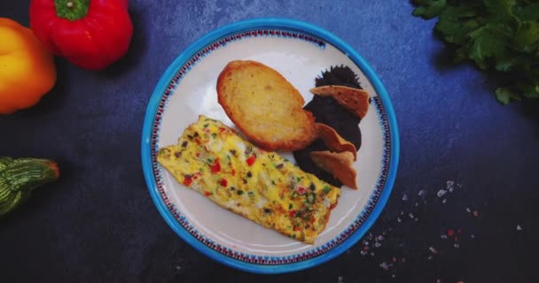 Talíř s lahodnou omeletou, tousty a smaženými fazolemi na černém povrchu — Stock video