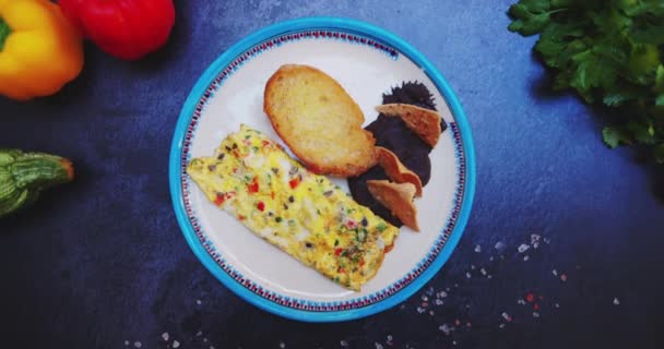 Placa con deliciosa tortilla, tostadas y frijoles refritos en la superficie negra — Vídeos de Stock