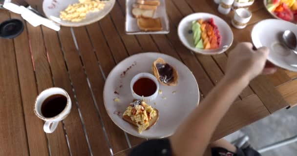 Manos femeninas alcanzando para plato por encima del plato con huevos revueltos y salsa — Vídeo de stock