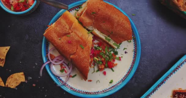Deliciosos sándwiches, pico de gallo y más comida en la superficie negra — Vídeos de Stock