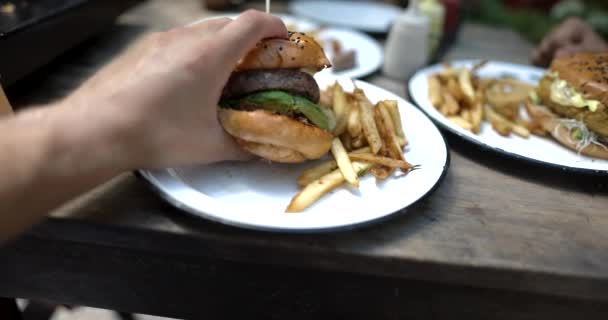 Férfi kézfogás ízletes hamburger tányérról sült krumplival — Stock videók