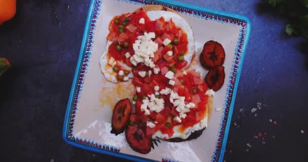 Talíř huevos rancheros a smažené banánové plátky na tmavém povrchu — Stock video