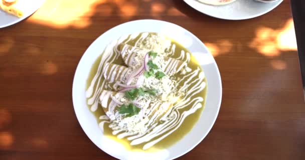 Placa de deliciosas enchiladas mexicanas verdes sobre mesa marrón — Vídeo de stock