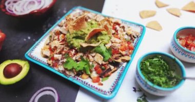 İki renkli yüzeyde guacamole soslu lezzetli et tabağı.