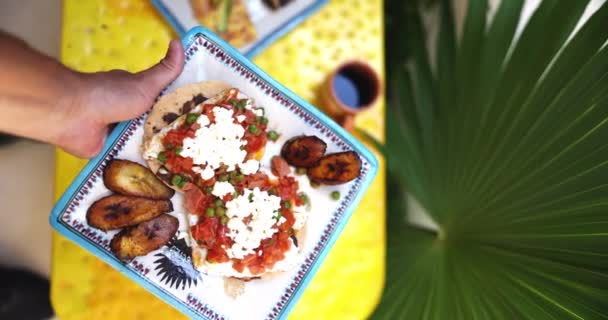 Χέρι τοποθέτηση πλάκα από huevos rancheros σε κίτρινη επιφάνεια — Αρχείο Βίντεο