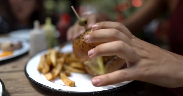 Wanita cantik meraih burger vegan lezat dengan latar belakang kabur — Stok Video