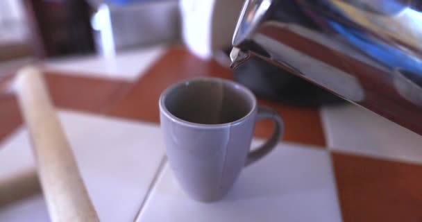 Kávé öntése szürke bögrébe csempe felett