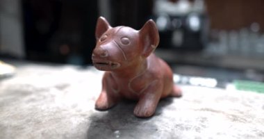 Parlak yüzeyde bulanık arkaplanı olan küçük bir Meksikalı köpek heykeli.