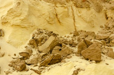 Weathered sand sculptures or formations with brown rock stones. Sand is a loose sedimentary rock, as well as an artificial material consisting of rock grains.