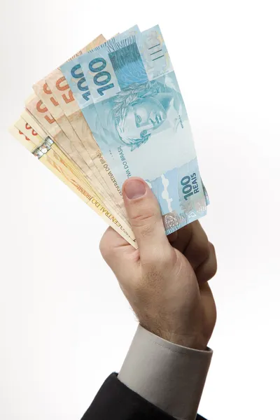 In possesso di un denaro brasiliano . Immagine Stock