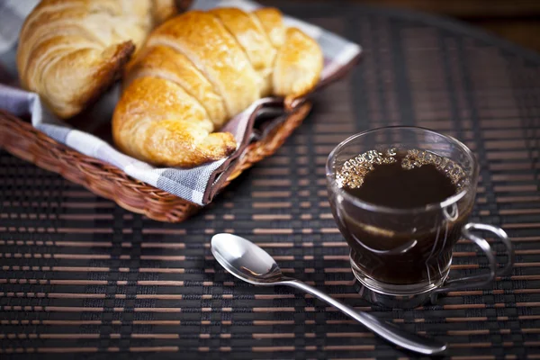 Uma xícara de café com cesta de croissant — Fotografia de Stock
